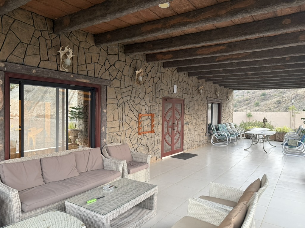 Exterior stone veranda with seating at the Sindh hunting lodge